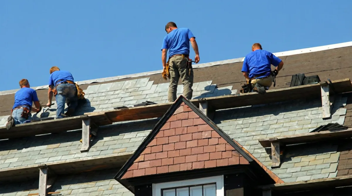 Roof replacement in progress with a team of professional contractors installing new shingles on a residential home in Bellevue, WA